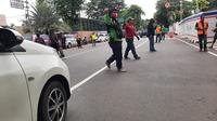 Komunitas ojek online (ojol) membantu mengatur arus lalu lintas di sekitar Gereja Katedral, Jakarta Pusat, Sabtu (25/12/2021). (Liputan6.com/ Ady Anugrahadi)