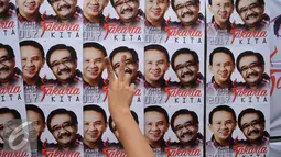 Salam dua jari didepan poster Calon Gubernur dan Wakil Gubernur DKI Jakarta Nomor Urut Dua, Ahok-Djarot saat kegiatan pengobatan gratis di Pengadegan Barat, Pancoran, Jakarta, Kamis (26/1). (Liputan6.com/Gempur M. Surya)