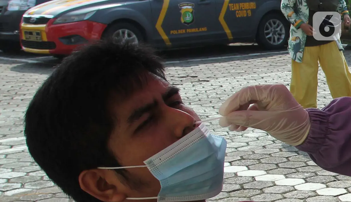 Seorang warga saat mengikuti pemeriksaan tes swab antigen di Polsek Pamulang, Tangerang Selatan pada Rabu (19/5/2021). Swab antigen gratis itu bagi warga Pamulang yang sudah kembali usai menjalani perjalanan mudik untuk antisipasi penularan virus corona COVID-19. (merdeka.com/Arie Basuki)