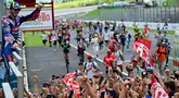 Pembalap Ducati Lenovo, Francesco Bagnaia melakukan selebrasi dengan para penggemarnya usai memenangi balapan MotoGP Italia di Mugello, 2 Juni 2024. (Marco BERTORELLO/AFP)
