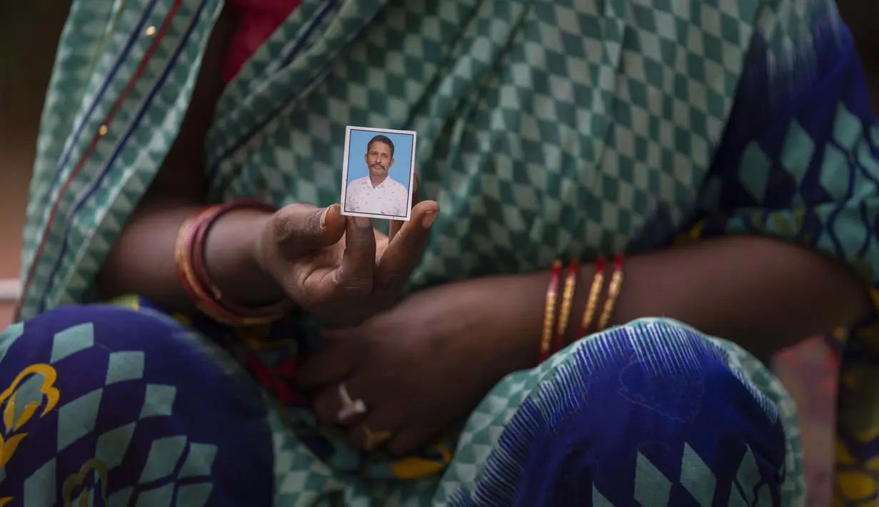 Savita Devi menunjukkan foto suaminya Manoj yang tubuhnya tidak dapat diidentifikasi setelah kecelakaan kereta api hari Jumat di Balasore, di rumah sakit All India Institute of Medical Sciences di Bhubaneswar, di negara bagian timur Odisha, India, Selasa (6/6/2023). (AP Photo/Rafiq Maqbool)