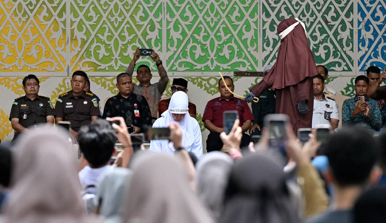 Seorang wanita menjalani hukuman cambuk setelah dinyatakan bersalah melanggar hukum syariat Islam Aceh yang melarang hubungan seksual di luar nikah di Banda Aceh,  Kamis, 20 Agustus 2026. (AFP/ Chaideer Mahyuddin)