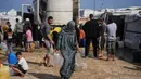 Situasi ini semakin parah akibat blokade Israel, kerusakan infrastruktur, dan pembatasan bantuan, yang memaksa warga antre untuk mendapatkan bantuan air bersih yang terbatas. Tampak dalam foto, Samah Abu Daqqa, 33 tahun, membawa jerigen berisi air melalui perkemahan tenda di Khan Younis, Jalur Gaza Selatan, Kamis 30 April 2026. (AP Photo/Abdel Kareem Hana)