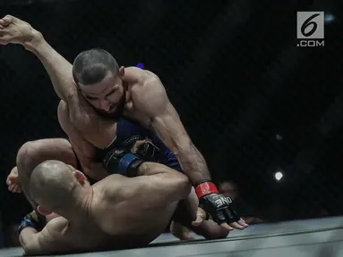 Petarung Rusia, Yusup Saadulaev (bawah) dan petarung Jepang, Masakazu Imanari saling menyerang pada pertarungan One Championship di Jakarta Convention Center (JCC), Sabtu (20/1). Pertarungan dimenangkan oleh Yusup Saadulaev. (Liputan6.com/Faizal Fanani)