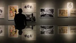 Petugas mengamati karya dalam Pameran Fotografi dan Grafis bertajuk “Indonesia Bergerak: 1900-1942“ di Galeri Foto Jurnalistik Antara, Pasar Baru, Jakarta, Selasa (8/9/2020). Pameran tersebut berlangsung hingga 7 Oktober 2020. (Liputan6.com/Immanuel Antonius)