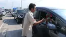 Petugas Lintas Marga Sedaya (LMS) menghampiri pengendara untuk menagih uang tol di pintu keluar Pejagan, Jawa Tengah, Sabtu (2/7). Sistem 'jemput bola' pembayaran tiket tol itu untuk mengurai kemacetan saat arus mudik. (Liputan6.com/Angga Yuniar)