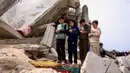 Pemandangan memilukan terlihat saat ratusan warga Palestina, termasuk anak-anak, berkumpul untuk melaksanakan salat Jumat di antara puing-puing masjid yang hancur akibat serangan Israel. Tampak dalam foto, anak-anak muda Palestina berdoa saat salat Jumat terakhir di bulan suci Ramadan 1447 Hijriah, di luar Masjid Al-Talbani, yang dihancurkan oleh militer Israel di Khan Yunis, Jalur Gaza selatan pada Jumat 13 Maret 2026. (Bashar Taleb/AFP)