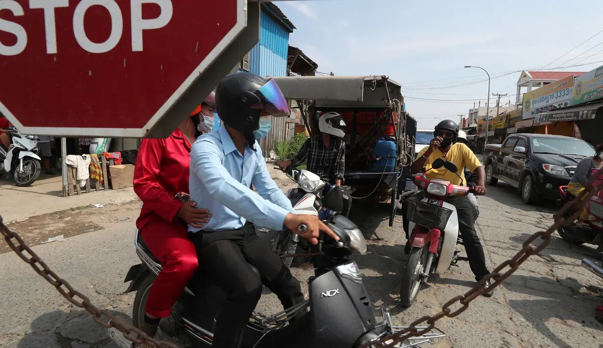 Orang-orang diblokir oleh petugas polisi setempat untuk masuk ke jalan kota utama dekat bandara Internasional Phnom Penh di Phnom Penh, Kamis (15/4/2021). Pemimpin Kamboja memutuskan untuk lockdown Phnom Penh selama dua minggu menyusul kenaikan tajam kasus COVID-19. (AP Photo/Heng Sinith)