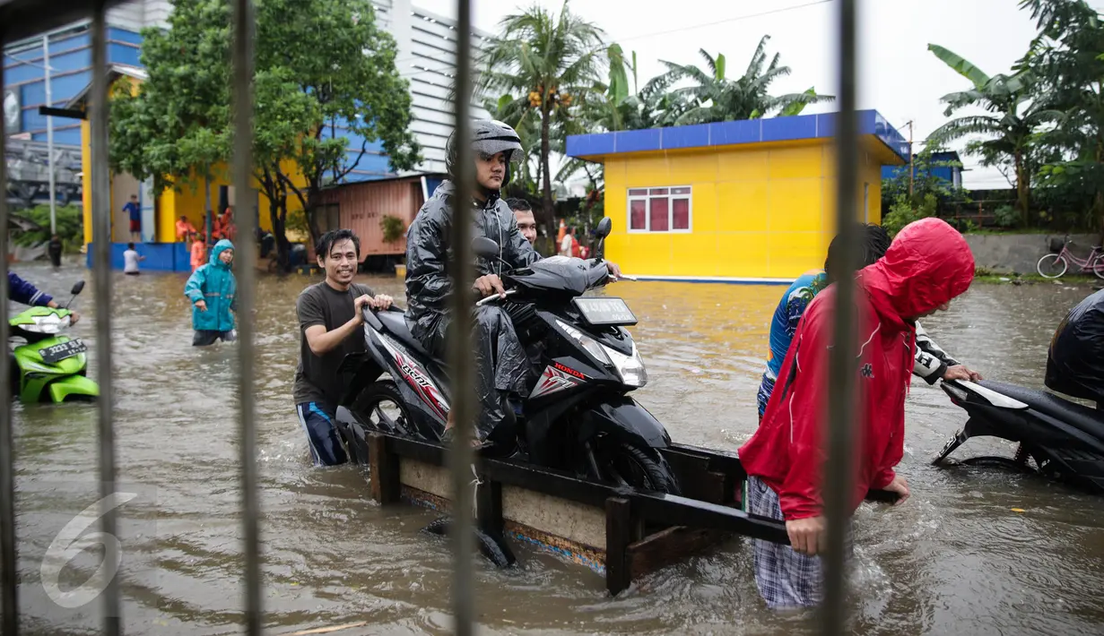 Seorang pengendara motor menggunakan jasa gerobak untuk menerobos banjir di Jalan Gunung Sahari, Jakarta Pusat, Selasa (21/2). Hujan deras yang mengguyur sejak Selasa dini hari membuat sebagian wilayah di Jakarta banjir. (Liputan6.com/Faizal Fanani)