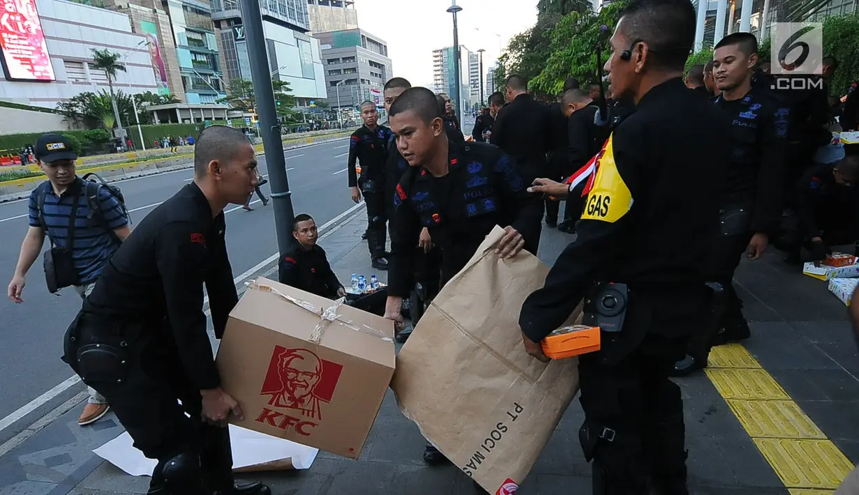 Aparat kepolisian yang melakukan penjagaan mendapatkan makanan berbuka puasa dari relawan TKN Jokowi-Ma'ruf Amin di kawasan Bundaran HI, Jakarta, Jumat (24/5/2019). Kegiatan ini sebagai bentuk kepedulian untuk aparat yang telah menjaga keamanan di Jakarta. (Liputan6.com/Angga Yuniar)
