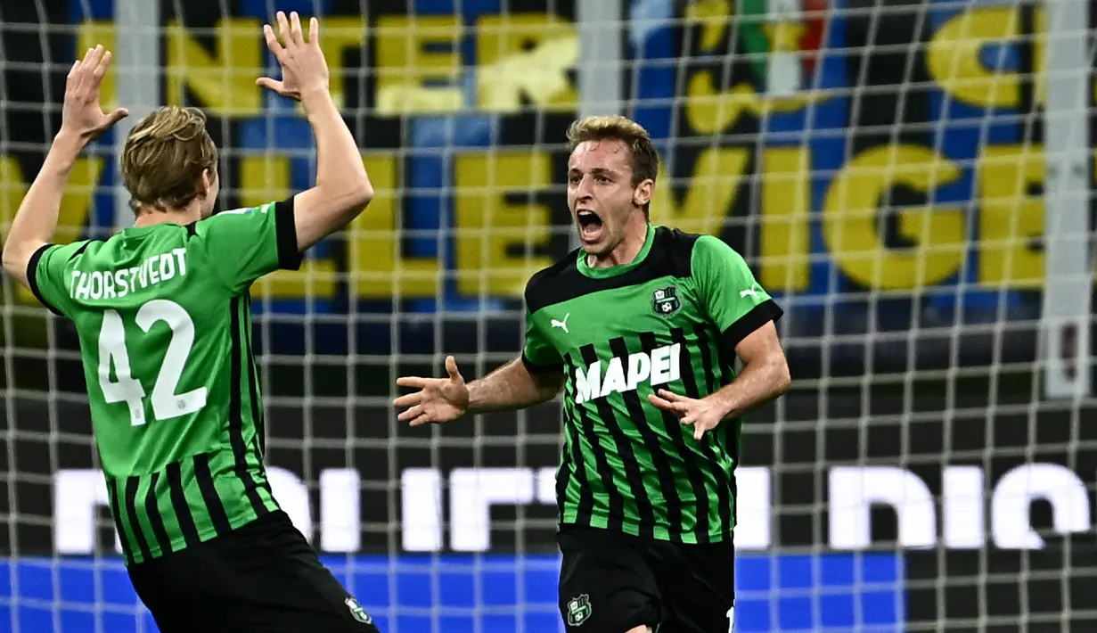 Pemain Sassuolo, Davide Frattesi (kanan) melakukan selebrasi bersama rekannya setelah mencetak gol kedua timnya ke gawang Inter Milan pada laga lanjutan Liga Italia 2022/2023 di Giuseppe-Meazza, Milan, 13 Mei 2023. Frattesi tercatat telah memainkan 37 pertandingan di semua kompetisi dengan mencetak tujuh gol bersama Sassuolo pada musim ini. Performa apiknya membuat klub-klub besar termasuk AC Milan tertarik untuk memboyongnya. (AFP/Gabriel Bouys)