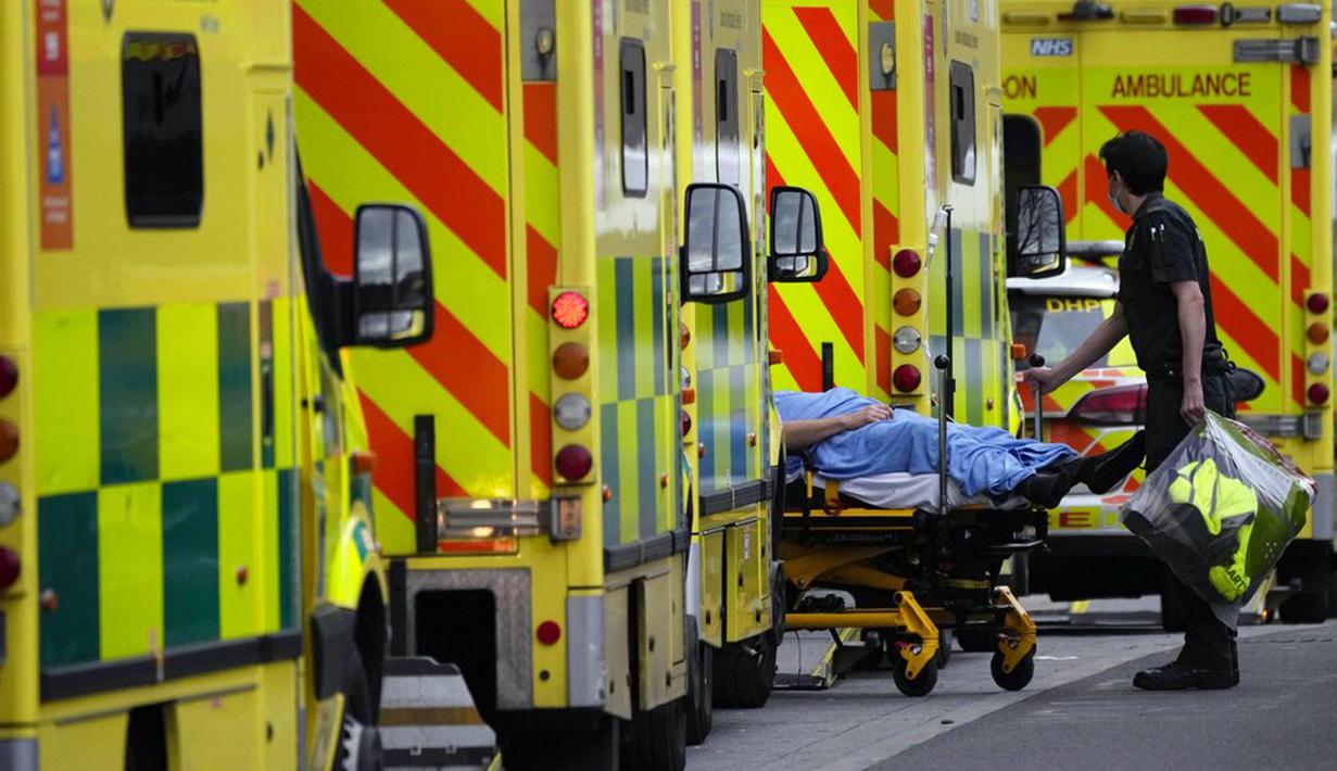 Seorang pasien didorong dengan troli setelah tiba dengan ambulans di luar Rumah Sakit Royal London, Inggris, 6 Januari 2022. Inggris memangkas waktu isolasi pasien COVID-19 dari 10 menjadi 7 hari karena kekurangan tenaga kesehatan akibat lonjakan kasus yang dipicu Omicron. (AP Photo/Matt Dunham)