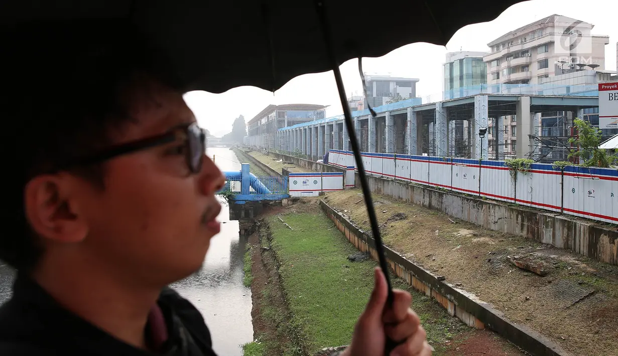 Warga melintas di dekat pembangunan proyek Stasiun Sudirman Baru di Jakarta, Minggu (23/7). Proyek tersebut ditargetkan selesai pada September 2017. (Liputan6.com/Immanuel Antonius)