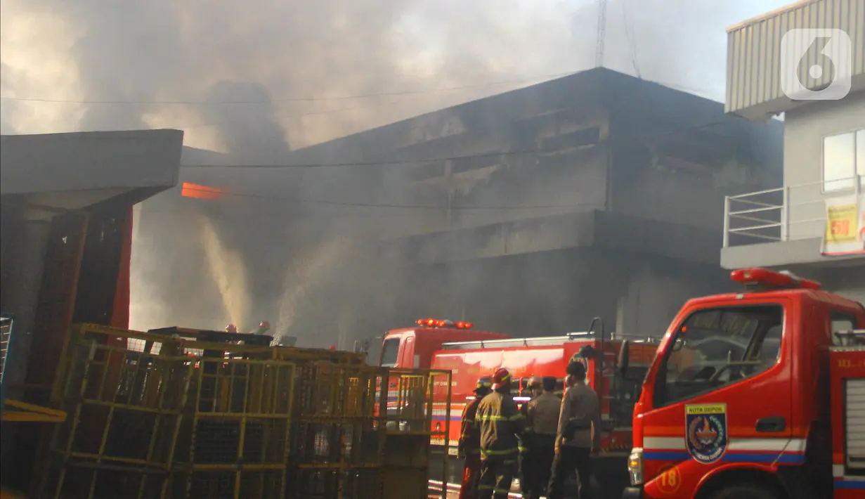 Petugas pemadam kebakaran berusaha memadamkan api yang membakar Gudang JNE Express di Jalan Pekapuran Raya, Depok, pada Senin (12/9/2022).  Awalnya api kecil datang dari sebelah barat Gudang JNE, kemudian menyambar hingga menghanguskan gedung yang lain. (Liputan6.com/Herman Zakharia)
