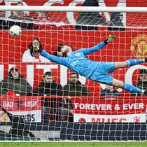 Kiper Manchester United, David de Gea, berusaha menghalau bola saat melawan Fulham pada laga Liga Inggris di Stadion Old Trafford (19/3/2023). (AFP/Paul Ellis)