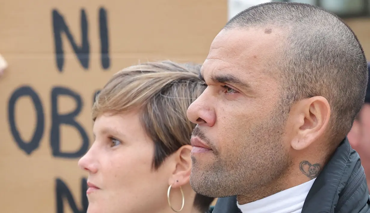 Pemain Brasil, Dani Alves (kanan) bersama pengacaranya, Ines Guardiola berjalan meninggalkan penjara Brians 2 di San Esteban Sasroviras, Barcelona, Spanyol, 25 Maret 2024. Alves bebas dari penjara setelah membayar uang jaminan 1 juta euro ke Pengadilan Barcelona. (AFP/Lluis Gene)