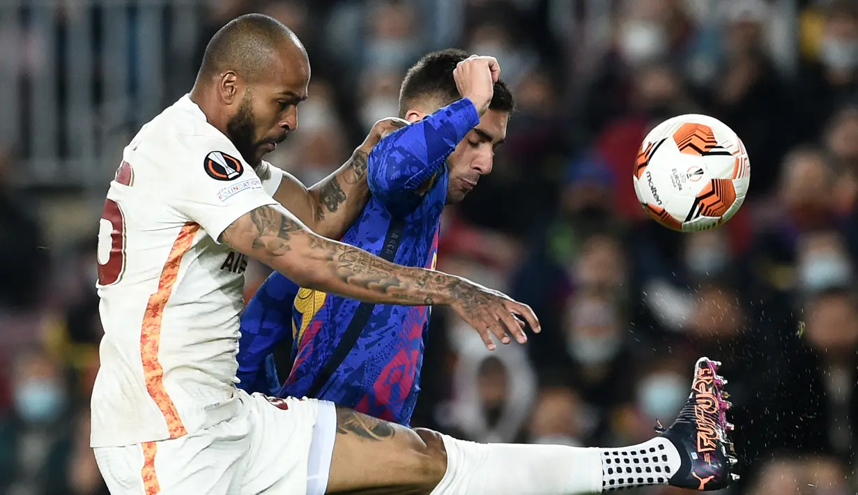 Bek Galatasaray, Marcao (kiri) berebut bola dengan penyerang Barcelona, Ferran Torres selama pertandingan leg pertama babak 16 besar Liga Europa di stadion Camp Nou di Barcelona (11/3/2022). Barcelona bermain imbang atas Galatasaray 0-0. (AFP/Lluis Gene)