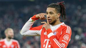 Pemain Bayern Munchen, Michael Olise menggiring bola melewati pemain VfL Wolfsburg dalam laga lanjutan Liga Jerman 2025/2026 di Allianz Arena, Munchen, Jerman, Minggu (11/01/2026) waktu setempat. (AFP/Alexandra Beier)