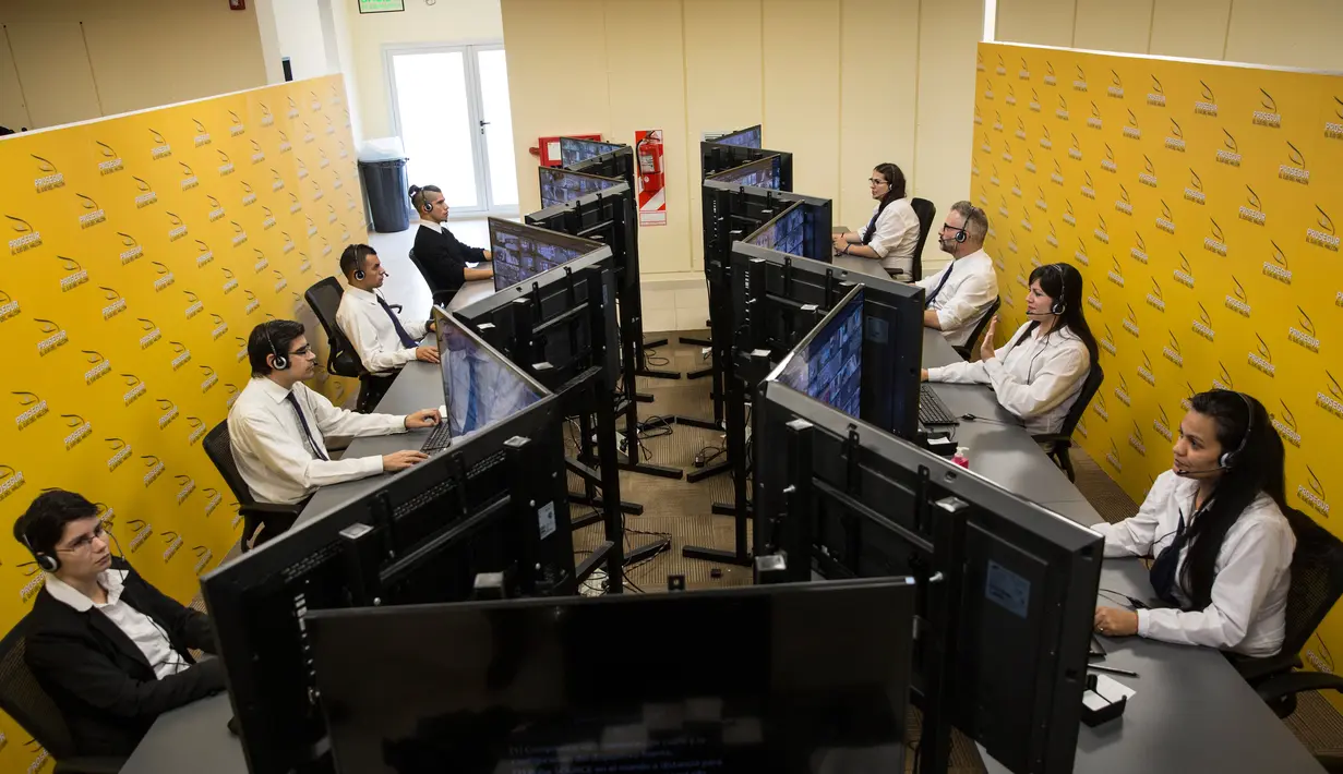 Operator penjaga keamanan virtual bekerja di kantor pusat Ojo del Halcon di Buenos Aires, Argentina, Rabu (25/4). Setiap operator memonitor dua gedung dengan 20 hingga 30 kamera keamanan. (AP Photo/Rodrigo Abd)