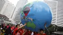 Sebuah miniatur bola dunia ikut dibawa saat aksi  mendukung ratifikasi Kerangka Kerja Pengendalian Tembakau (FCTC) di Bundaran HI, Jakarta, Minggu (15/2/2015). (Antara Foto/ Sigid Kurniawan)