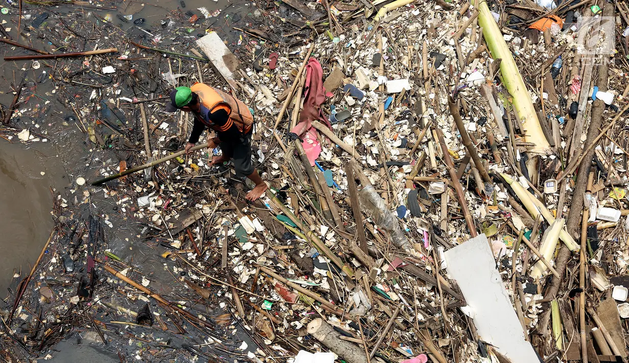 Petugas kebersihan Pemprov DKI Jakarta mencoba mengurai sampah yang terbawa arus di Pintu air Manggarai, Jakarta, Senin (2/10). Pembersihan itu dilakukan untuk melancarkan aliran Sungai Ciliwung yang melewati Pintu Air Manggarai (Liputan6.com/Johan Tallo)