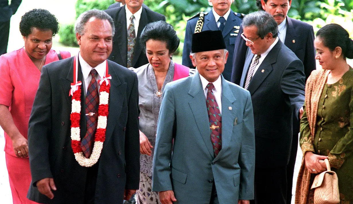 Presiden BJ Habibie (kanan) bersama istrinya Ainun Habibie menyambut kedatangan Perdana Menteri Papua Nugini Bill Skate (kiri) beserta istrinya Rarua di Istana Presiden, Jakarta, 3 Juni 1998. Kisah cinta Habibie dan Ainun menyita perhatian publik hingga difilmkan. (AFP Photo/Agus Lolong)
