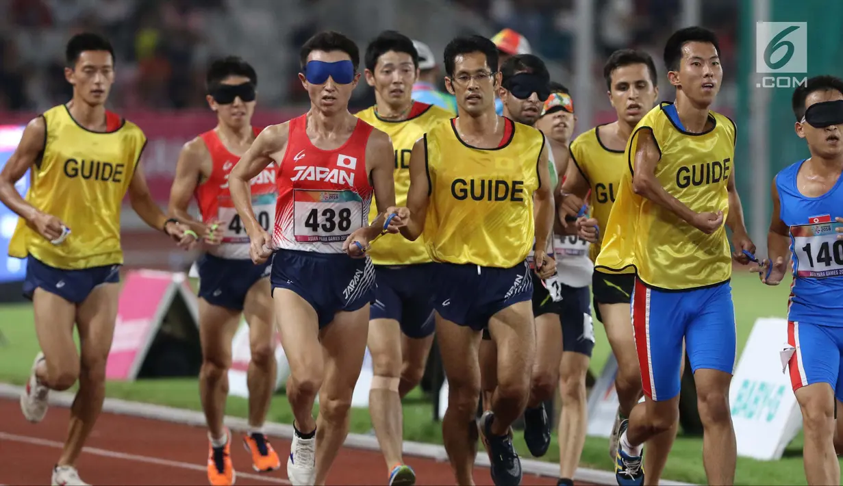 Pelari 5000 meter putra kategori T11 Asian Para Games 2018 saat laga final di SUGBK, Jakarta, Jumat (12/10). Pemandu kategori T11 juga harus memiliki fisik dan kemampuan yang sama atau lebih dari pelari utamanya. (Liputan6.com/Helmi Fithriansyah)