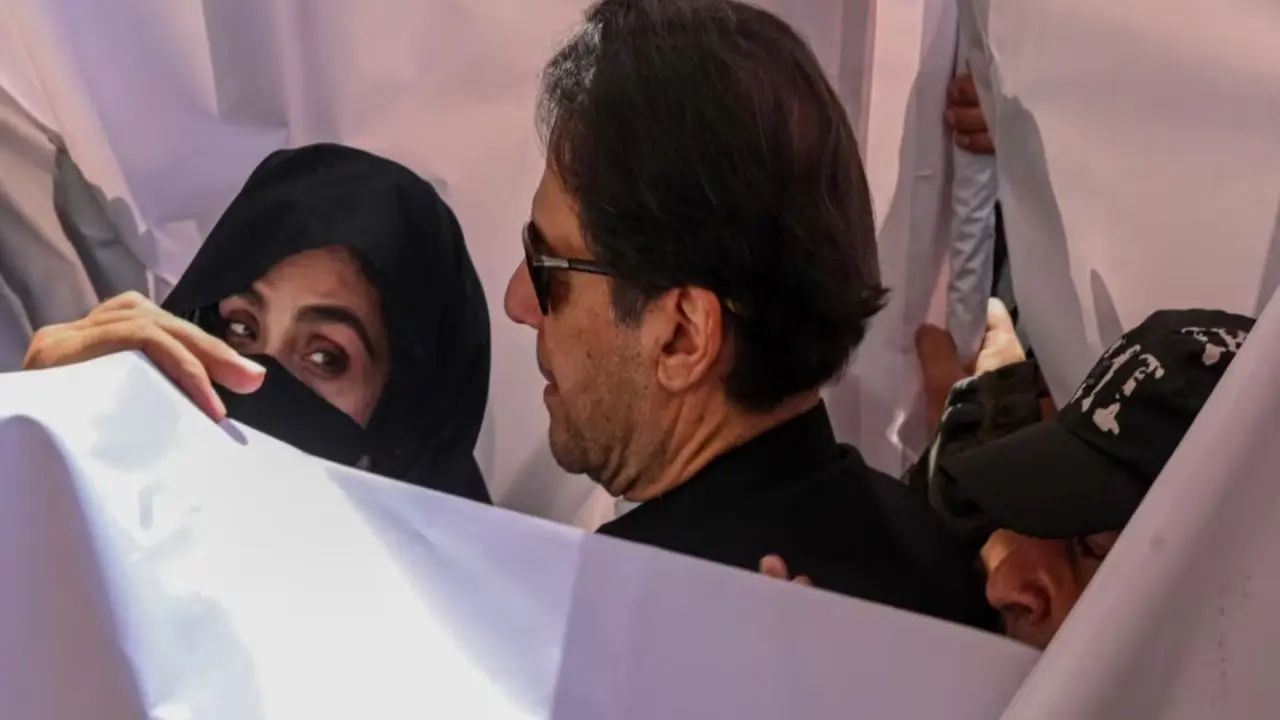 Mantan perdana menteri Pakistan Imran Khan (tengah) bersama istrinya Bushra Bibi (kiri). (AFP)