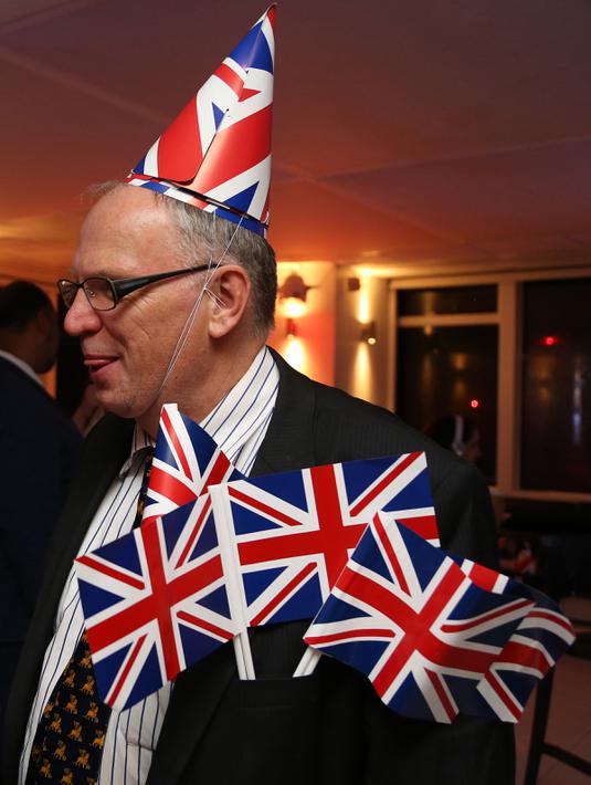 Pendukung Brexit mengenakan topi Inggris di pesta Leave.EU setelah melihat hasil penghitungan sementara referendum Inggris yang menunjukkan mayoritas rakyat Inggris memilih “Brexit” alias keluar dari Uni Eropa, di London, Kamis (23/6). (GEOFF CADDICK/AFP)