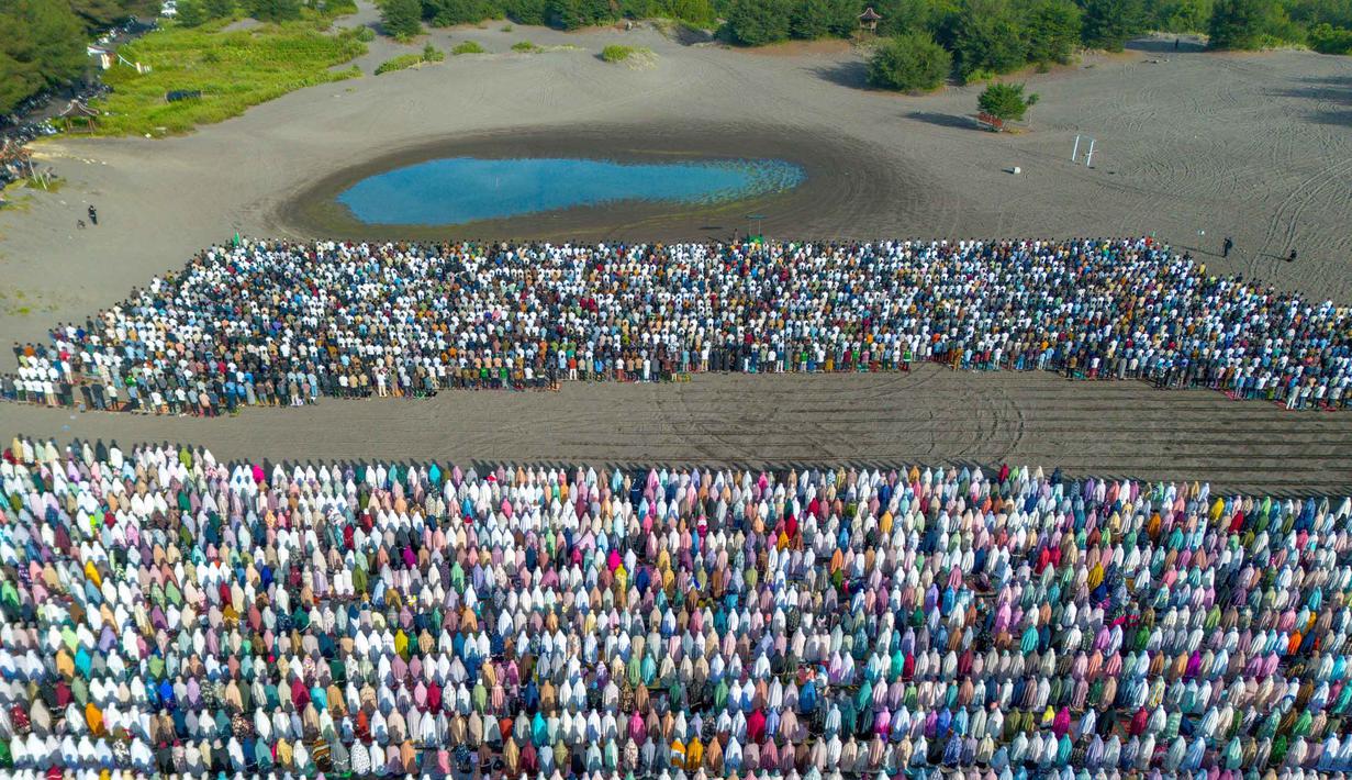 Hari ini Jumat 20 Maret 2026, jutaan umat muslim Muhammadiyah di seluruh Indonesia menggelar salat Idul Fitri 1447 Hijriah. Tampak foto udara menunjukkan umat muslim saat melaksanakan salat Idul Fitri 1447 Hijriah yang juga menandai berakhirnya bulan suci Ramadan, di Pantai Parangkusumo, Bantul, Yogyakarta pada Jumat 20 Maret 2026. (DEVI RAHMAN/AFP)