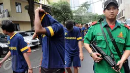 Petugas saat menggelandang 135 orang tersangka pengungkapan Narkoba oleh Ditresnarkoba, Jakarta (2/2). Ditresnarkoba Polda Metro Jaya beserta jajarannya mengungkap 106 kasus narkoba. (Liputan6.com/Helmi Afandi)