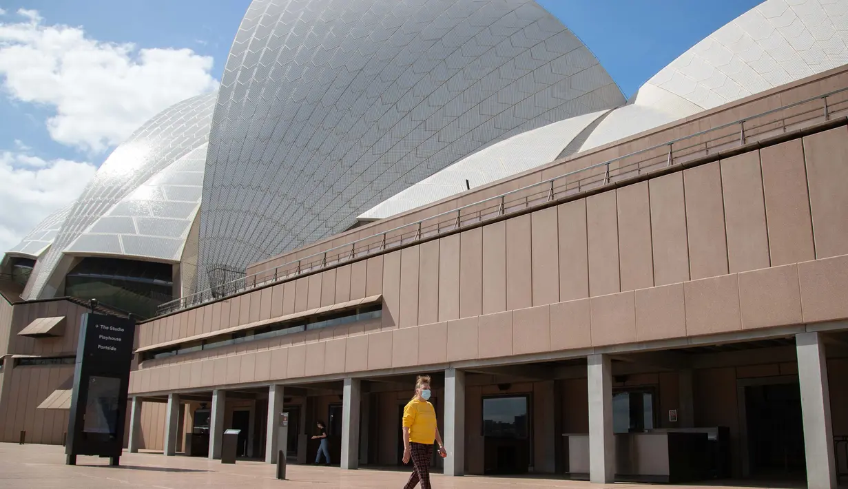 Seorang wisatawan berjalan melewati Sydney Opera House di Sydney, Australia, pada 1 September 2020. Sektor pariwisata di Australia terdampak parah oleh pandemi COVID-19. (Xinhua/Hu Jingchen)