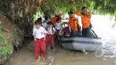 Siswa SD Negeri 1 Pajagan, Kabupaten Lebak, Banten, seusai menaiki perahu karet milik BNPB, Senin (16/3/2015). Pasca robohnya jembatan gantung di atas Sungai Ciberang, warga terpaksa menyeberang mengunakan perahu karet. (Liputan6.com/Herman Zakharia)