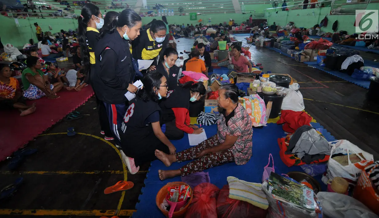 Petugas gabungan melakukan pendataan kepada pengungsi di Gor Swecapura, Klungkung, Bali, Sabtu (30/9). Pendataan tersebut dimaksudkan untuk mengetahui warga yang ikut evakuasi namun tidak dalam zona merah Gunungapi Agung. (Liputan6.com/Gempur M Surya)