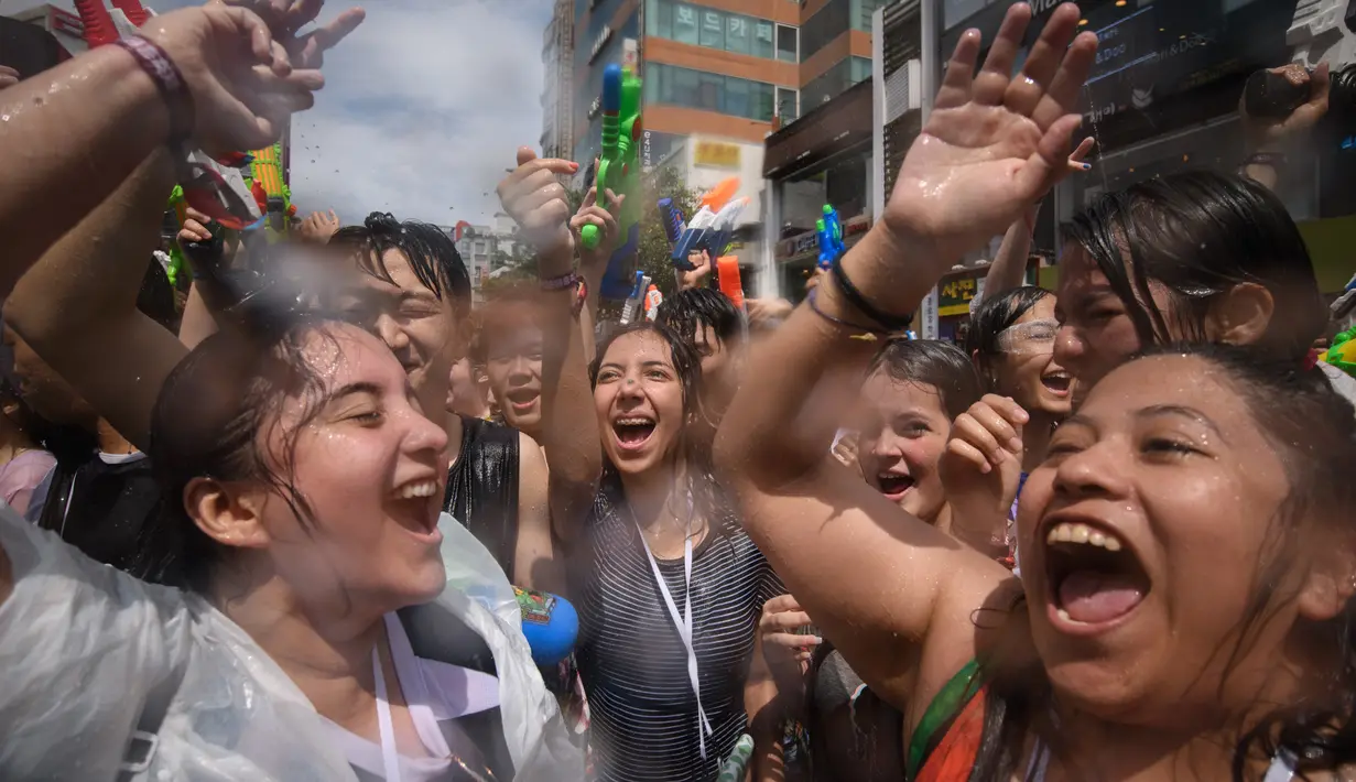 Para peserta bersuka ria selama Festival pistol air Sinchon di area Sinchon, Seoul, Minggu (7/7/2019). Festival musim panas yang membawa permainan air ke tengah kota ini cukup digandrungi baik warga lokal maupun wisatawan asing. (Photo by Ed JONES / AFP)