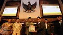 Wakil Ketua MPR RI Hidayat Nur Wahid (ketiga kiri) bertukar cenderamata bersama pengurus baru DMI Jakarta Selatan jelang memberikan materi Sosialisasi 4 Pilar MPR RI di Kompleks Parlemen RI, Jakarta, Selasa (29/3/2016). (Liputan6.com/Helmi Fithriansyah)
