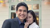 Nong Poy memamerkan cincin saat bersama calon suaminya. Dalam foto tersebut, ia mengenakan coat abu-abu dengan riasan wajah minimalis bahkan terlihat tanpa makeup. @poydtreechada.