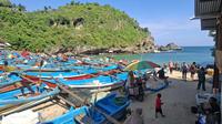 Wisatawan tetap memadati Pantai Ngrenehan, Gunungkidul, meski BMKG telah mengeluarkan peringatan dini gelombang tinggi di perairan selatan DIY pada Kamis (25/7/2025). Sejumlah perahu nelayan tampak bersandar, menandakan aktivitas melaut dihentikan sementara karena risiko cuaca ekstrem dan potensi arus balik berbahaya.