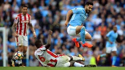 Bek Stoke City, Kurt Zouma berusaha merebut bola yang dibawa Gelandang Manchester City, Ilkay Gundogan saat bertanding pada lanjutan Liga Inggris di Etihad Stadium, Manchester, (14/10). City menang 7-2 atas Stoke. (Mike Egerton / PA via AP)