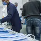 Orang-orang bekerja di sebuah pabrik yang memproduksi masker medis di Kairo, Mesir, 14 April 2020. Para karyawan bekerja siang dan malam untuk mengoperasikan lima mesin canggih yang dibawa dari China untuk memproduksi hingga 750.000 masker medis per hari. (Xinhua/Wu Huiwo)
