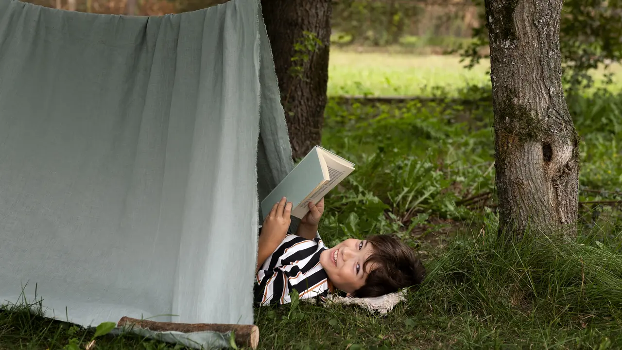 Ilustrasi anak membaca buku sambil tidur di tenda alam terbuka/freepik.com/pikisuperstar