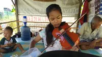 Jawa Nur Alam (13), gadis yang piawai memainkan alat musik biola yang videonya sempat ramai di media sosial. (Foto: Liputan6.com/Dian Kurniawan)