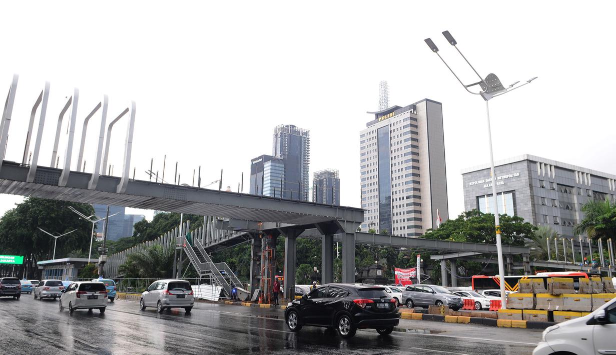 Kendaraan melintas jembatan penyeberangan orang (JPO) Polda Metro Jaya di kawasan Jenderal Sudirman, Jakarta, Sabtu (5/1). Revitalisasi tiga di kawasan Sudirman ditargetkan selesai pada pertengahan Januari 2019. (Liputan6.com/Herman Zakharia)