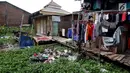 Warga menjemur pakaian di belakang rumah di kawasan Kampung Apung, Jakarta, Senin (6/11). Meski kampung tersebut terendam sejak tahun 1990-an, hingga kini warga masih tetap bertahan. (Liputan6.com/JohanTallo)