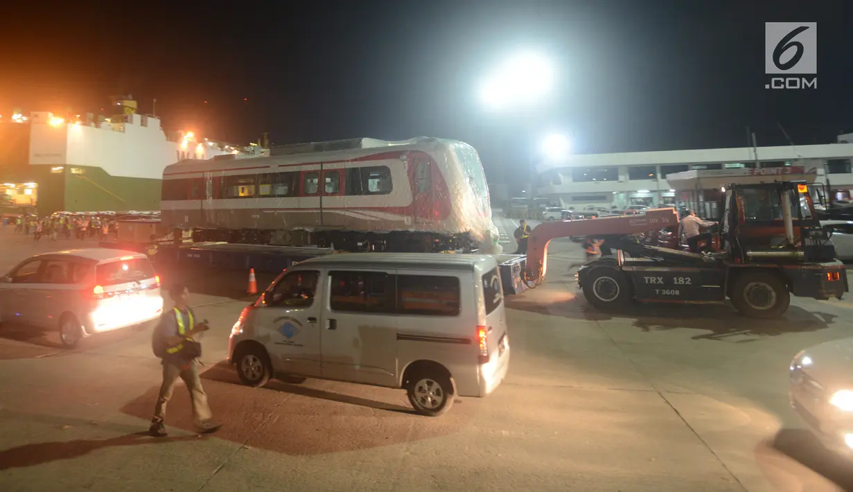 Pekerja dibantu alat berat menarik gerbong kereta Light Rail Transit (LRT) di Pelabuhan Car Terminal, Tanjung Priok, Jakarta, Jumat (13/4). LRT ini akan dipergunakan dalam perhelatan Asian Games 2018 pada Agustus mendatang.  (Merdeka.com/Imam Buhori)