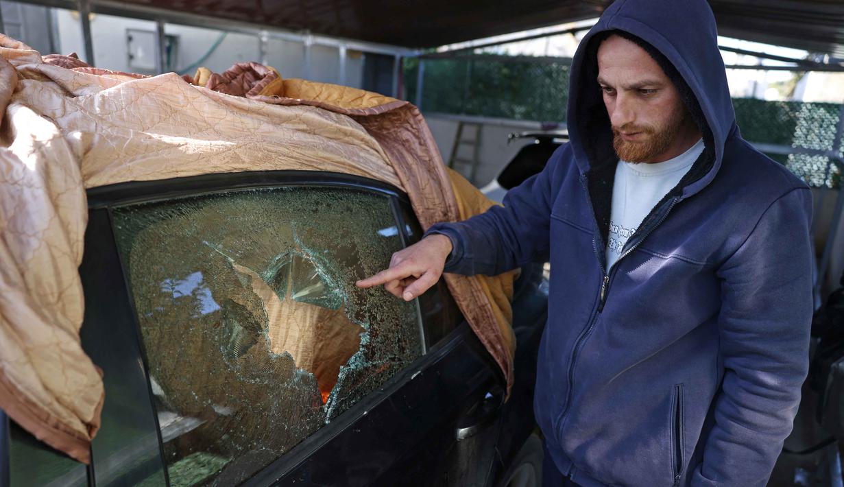 Kantor Perserikatan Bangsa Bangsa (PBB) untuk Koordinasi Urusan Kemanusiaan (OCHA) mencatat terdapat 264 serangan yang dilakukan pemukim Israel terhadap warga Palestina di Tepi Barat selama Oktober 2025. Tampak dalam foto, seorang pria Palestina mengarahkan tangannya ke kaca mobil yang rusak akibat serangan oleh pemukim Israel di desa Jabaa dekat Bethlehem, di Tepi Barat yang diduduki, pada Selasa 18 November 2025. (AHMAD GHARABLI/AFP)