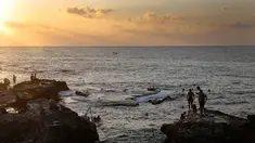 Sejumlah orang berenang di laut Mediterania dari Corniche, atau promenade tepi laut saat matahari terbenam selama hari terakhir musim panas, di Beirut, Lebanon (20/9). (AP Photo / Hussein Malla)