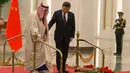  Presiden China Xi Jinping membantu Raja Arab Saudi Salman bin Abdulaziz al-Saud berjalan saat mengikuti upacara penyambutan di Beijing, China (16/3). (AP Photo / Ng Han Guan)