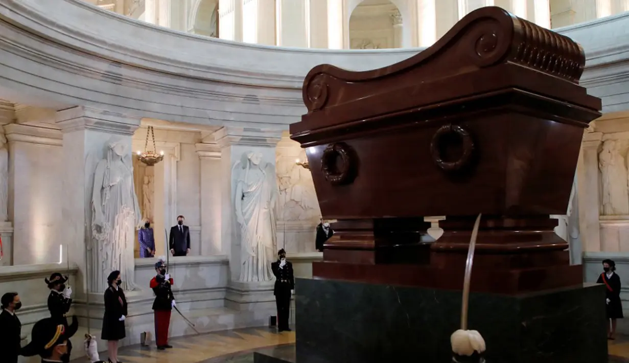 Presiden Prancis Emmanuel Macron dan istrinya Brigitte Macron berdiri di depan makam Kaisar Prancis Napoleon (1769-1821) saat upacara peringatan 200 tahun kematiannya di Chapelle Saint-Jerome, Invalides, Paris, Prancis, Rabu (5/5/2021). (SARAH MEYSSONNIER/POOL/AFP)
