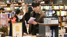 Sepasang pengunjung membaca buku di toko buku di Seoul, setelah Korea Selatan mencabut mandat masker dalam ruangan saat kasus Covid berkurang, Senin (30/1/2023). Korea Selatan mencabut mandat masker dalam ruangan pada 30 Januari ini, menghapus salah satu pembatasan era pandemi terakhir negara itu, tetapi banyak orang memilih untuk tetap menutupi wajah mereka. (Jung Yeon-je / AFP)